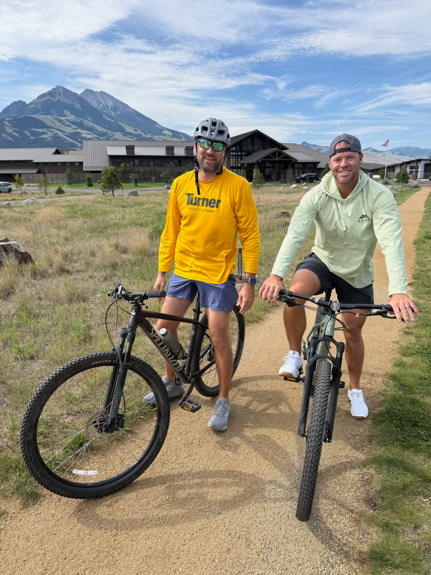 Two mountain bikes parked on a trail in front of the lodge
