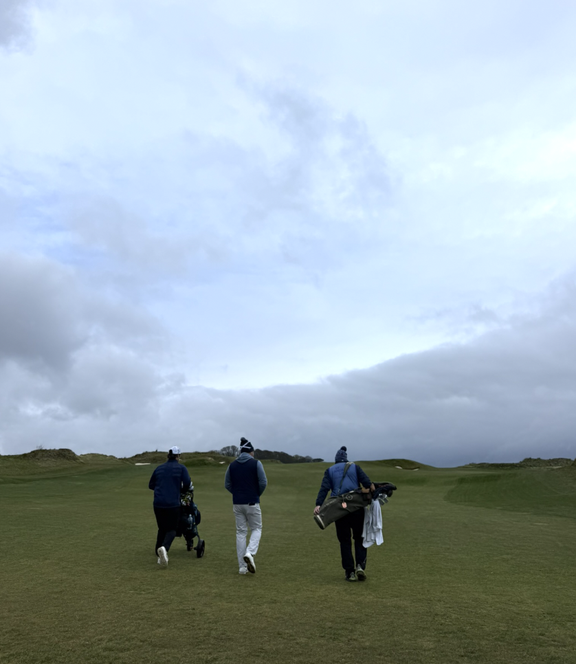 Golfers walking across a coastal St Andrews course