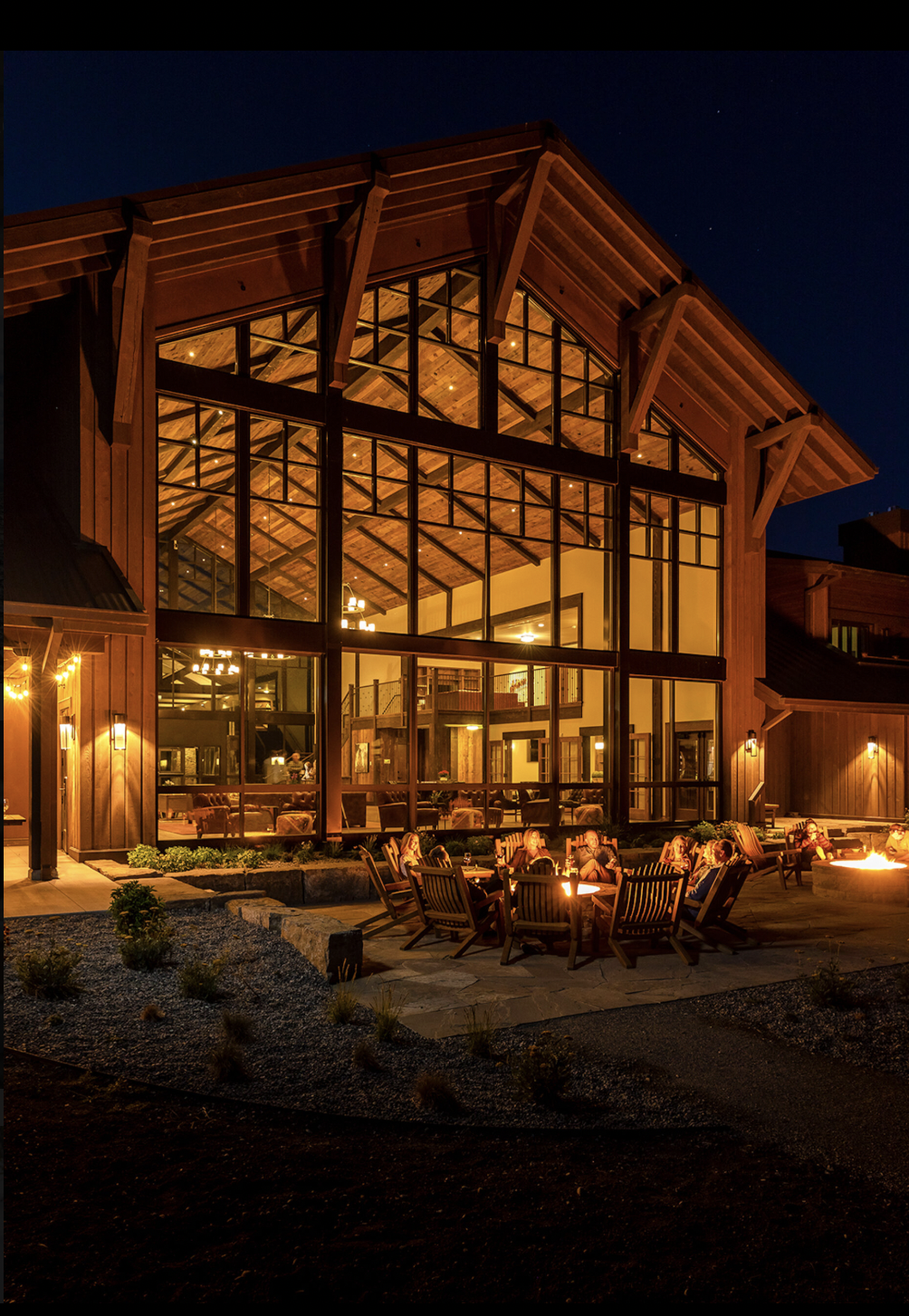 Guests gathered around the fire pits outside Sage Lodge at night