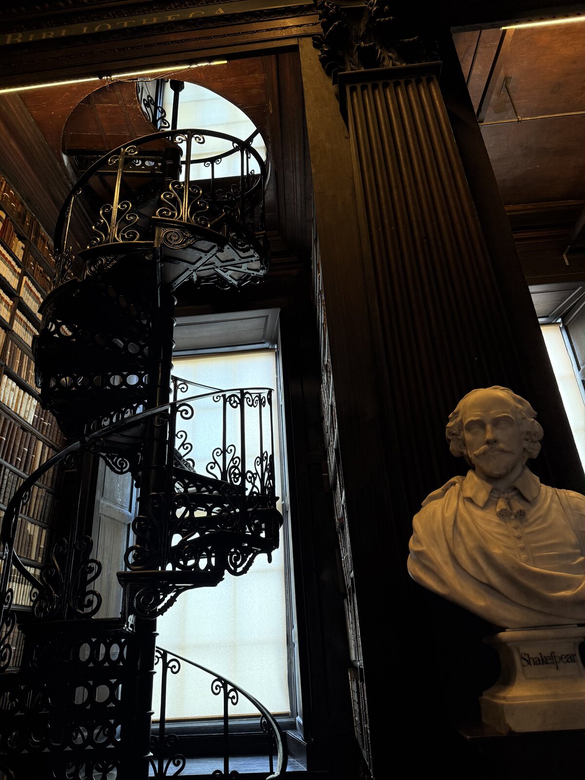 Spiral staircase and marble bust in the Long Room