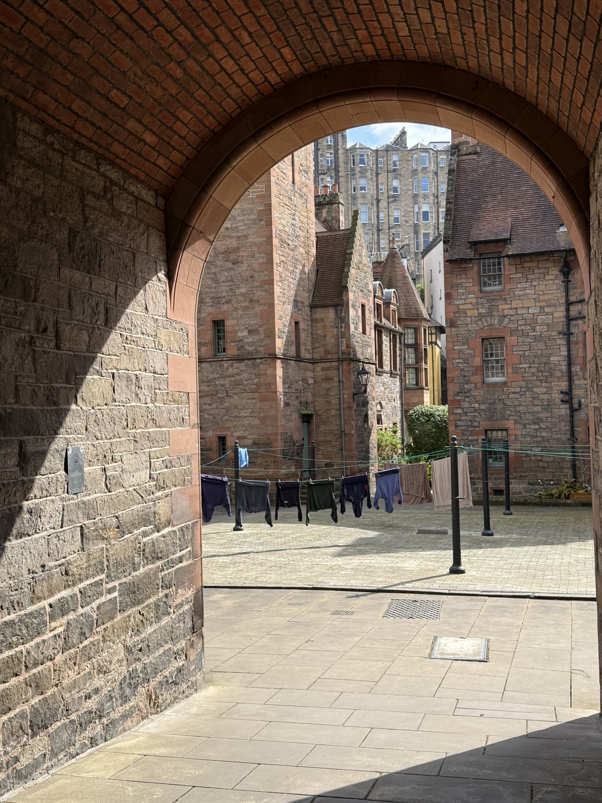 A brick archway opening onto an Edinburgh Old Town courtyard