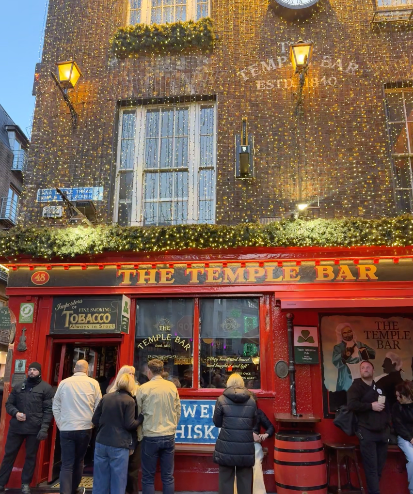 The red front of The Temple Bar pub with holiday lights