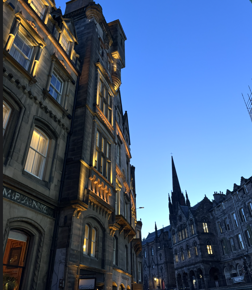 Historic Edinburgh buildings and a church spire at dusk